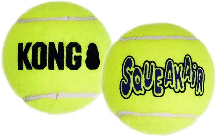 Två gulgröna tennisbollar visas. En boll har ordet "KONG" och märkets logotyp tryckt i svart. Den andra bollen har ordet "Squeakair" i blått med en svart kontur. Båda bollarna har en vit rand runt omkretsen, vilket gör dem perfekta för din lekfulla hund eller katt.