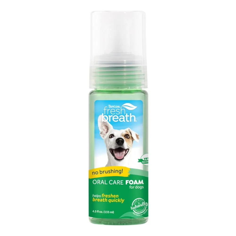 En 4,5 fl oz (133 ml) flaska TropiClean Fresh Breath Oral Care Foam för hundar. Flaskan har ett spraymunstycke och en etikett med en glad hundbild, vilket indikerar att den hjälper till att fräscha upp andedräkten snabbt utan att borsta. Produkten rekommenderas av veterinär och är naturlig.