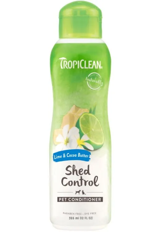 En flaska TropiClean Shed Control Pet Conditioner med lime och kakaosmör. Den gröna och vita flaskan, med en limeskiva och vita blommor, innehåller 355 ml (12 fl oz) parabenfri, färgämnesfri produkt. Perfekt för din hunds eller katts skötselrutin.